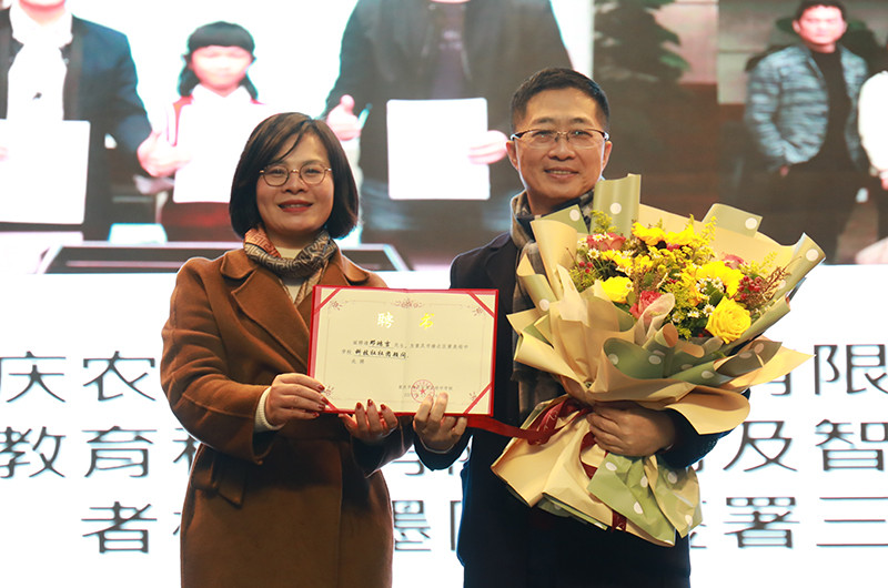 魏莉為鄧鴻吉頒發學校聘書。黃炎培中學供圖