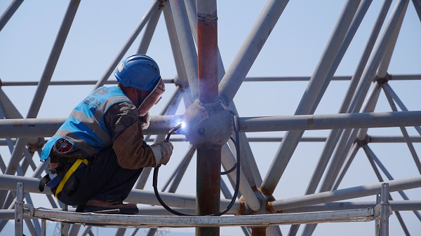 工人正在進行鋼架結構施工。唐鑫攝