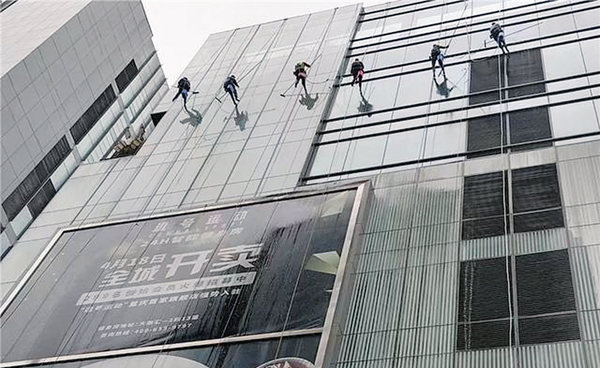 “蜘蛛人”正在從上至下清洗大樓玻璃外墻。