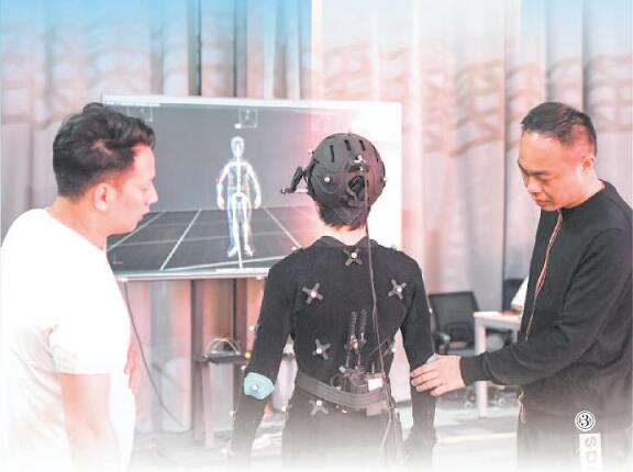 盧琪（右）在影像科技虛擬攝影棚與工作人員交流。王全超攝（人民視覺）