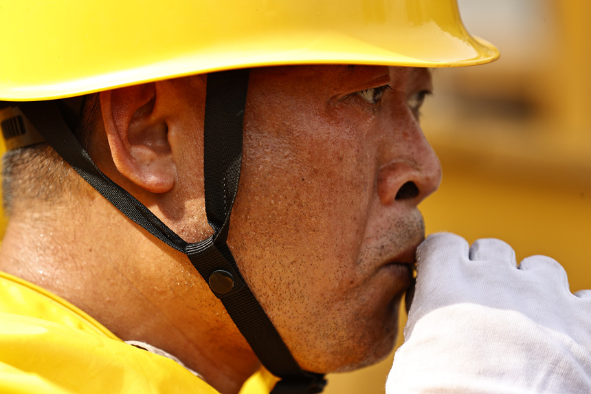 作業結束后，工作人員喝下藿香正氣液進行消暑。國網重慶市電力公司供圖