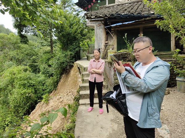 《群眾安全無小事》。6月15日，黔江區金溪規劃和自然資源所會同107地質隊總工路政坤（右）在金溪鎮清水村祝家巖查看農戶屋角發生的局部垮塌險情，并提出專業意見。李偉攝