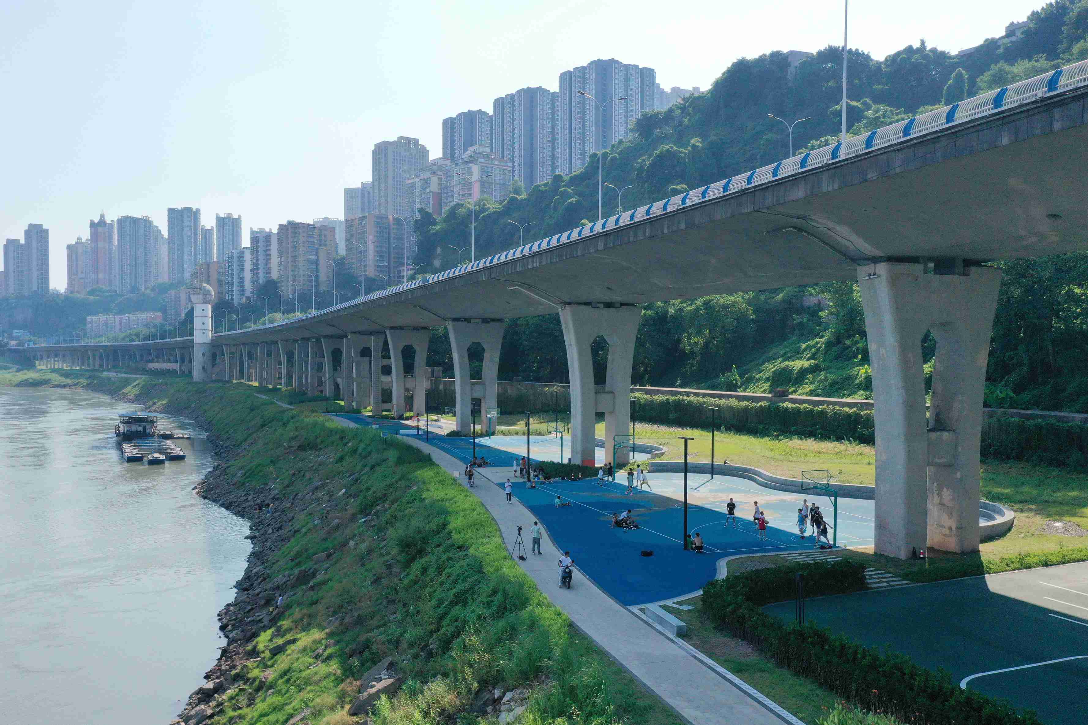 在渝中區黃沙溪大橋下，市民在長江邊的籃球場打球。何超攝
