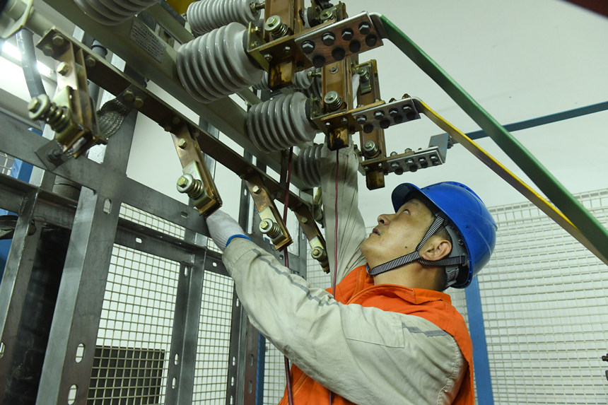 8月10日晚，國家電網紅巖（璧山運檢）共產黨員服務隊隊員在110千伏大路變電站檢修3號電容器。周毅攝