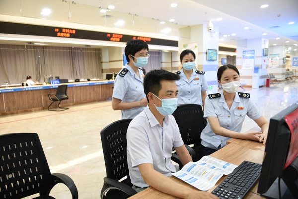 稅務特約監督員在辦稅服務廳自助辦稅區體驗電子稅務局“十七稅”合并申報、發票領用等功能。陳紅梅攝