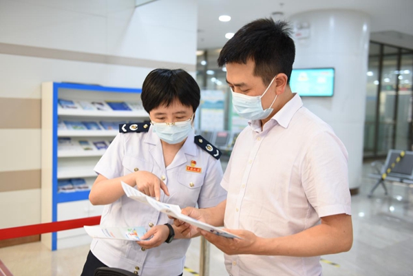 在辦稅服務廳，稅務人員向稅務特約監督員介紹今年組合式減稅降費政策內容。陳紅梅攝