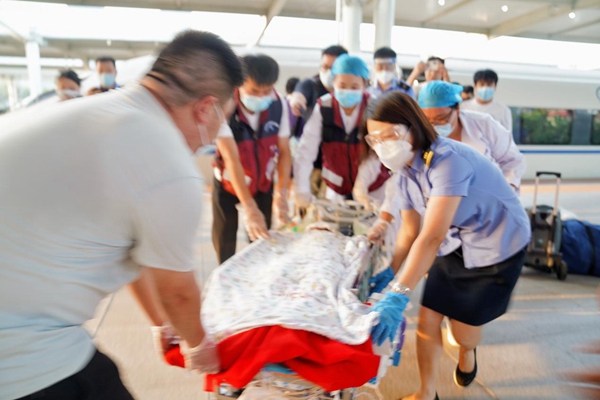 車站工作人員協助醫護人員轉運燒傷患兒。汪亮攝