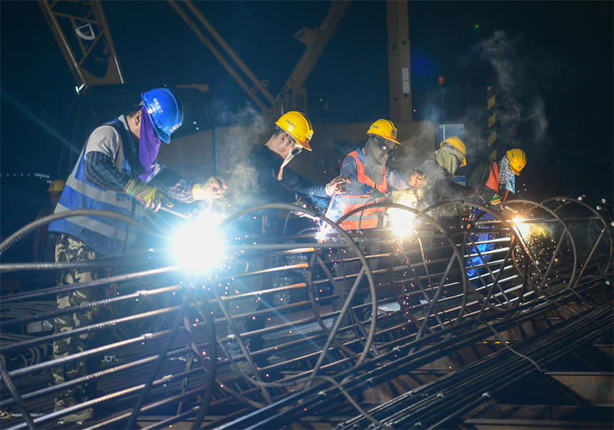 工作人員正在進行夜間鋼筋電焊作業。郭旭攝