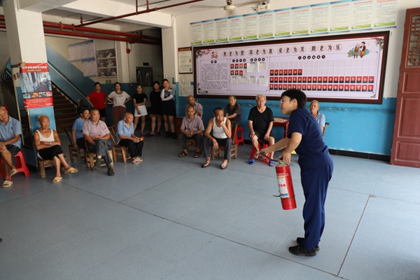 消防宣傳員向群眾講解滅火器的使用方法。秀山縣消防救援大隊供圖