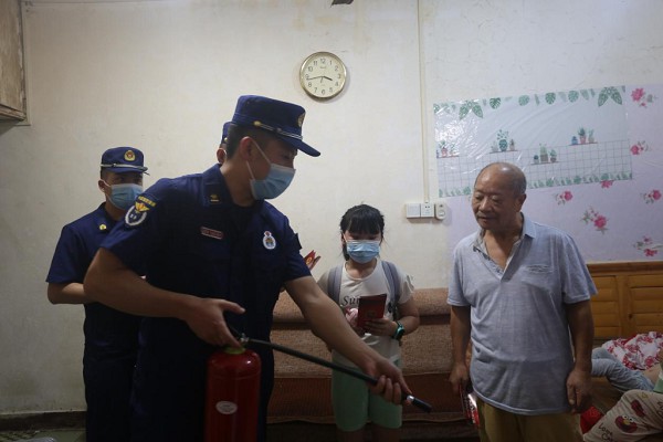 消防宣傳員為居民示范滅火器的使用方法。渝中區消防救援支隊供圖