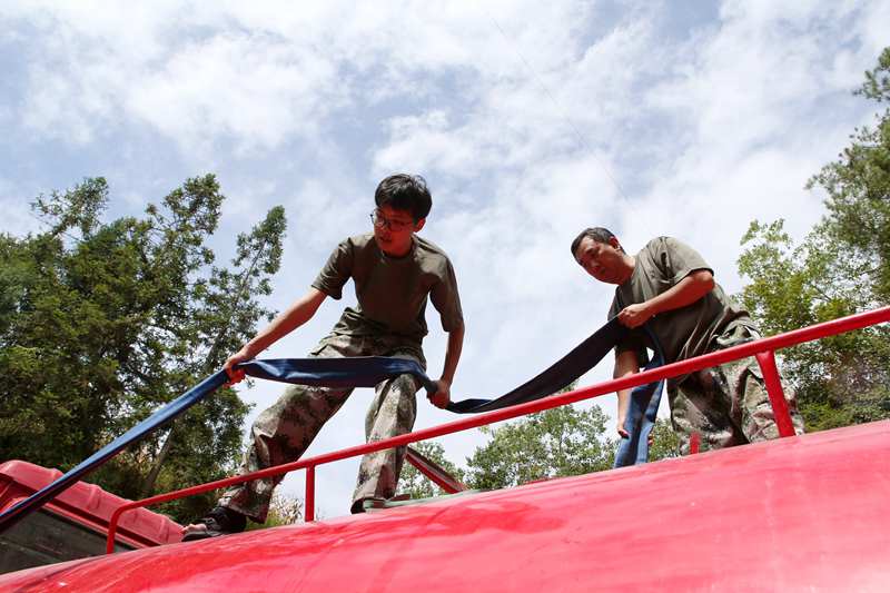 專班人員在新花村新找的水源點給送水車裝水。楊敏攝