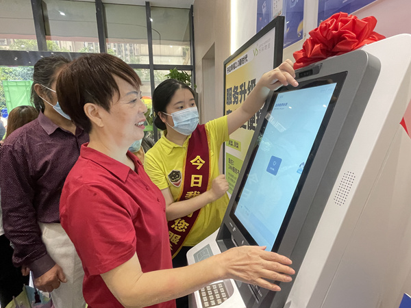 物業工作人員引導業主操作“鳳梨一號”。萬科物業供圖