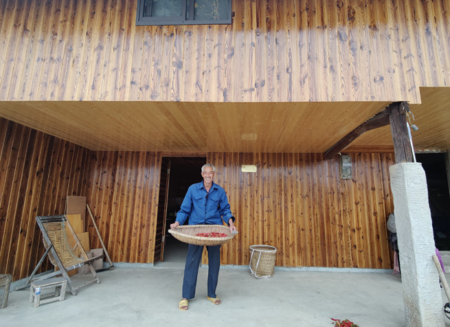 老黨員正在自家屋前篩小辣椒。徐俊聰攝