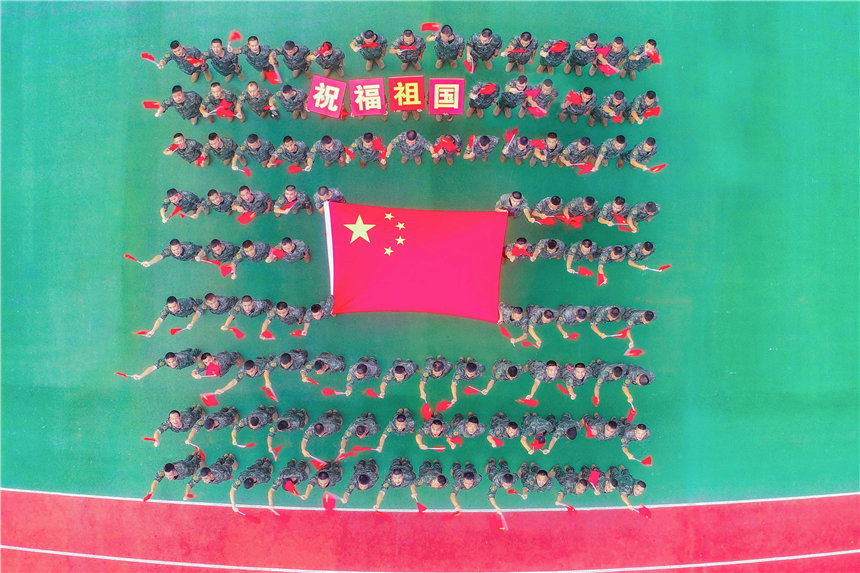 武警官兵與國旗合影，祝福祖國。李東攝
