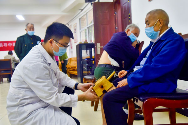 為老人進行艾灸治療。陶涵攝