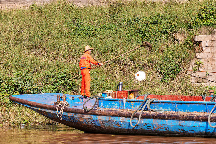 清漂工人清理江岸垃圾。余鴻攝