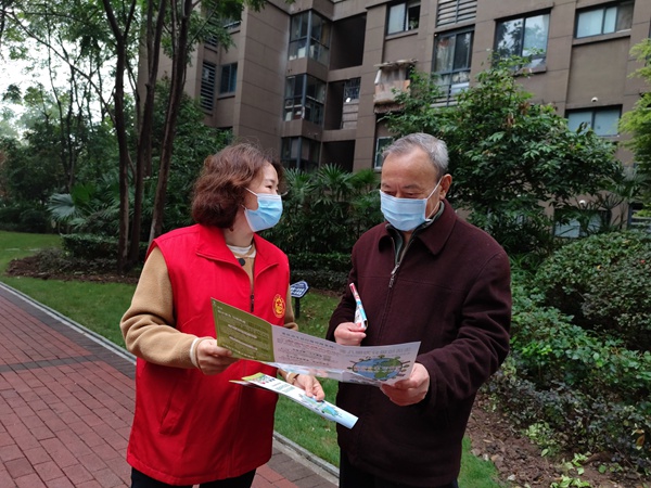 垃圾分類宣傳員給小區居民講解垃圾分類知識。