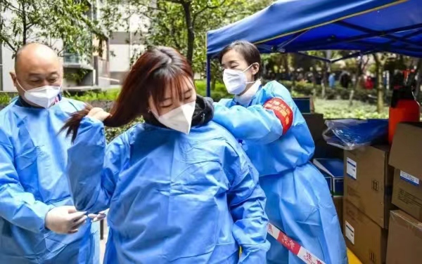 父女倆為參與防控工作做準備。南岸區融媒體中心供圖