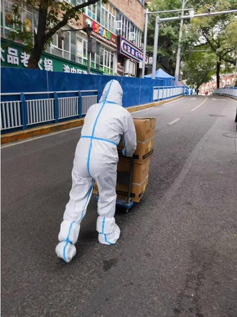 巴渝民宿集團所屬渝地物業公司嘉和苑項目工作人員配合社區運送醫療物資。渝地物業供圖