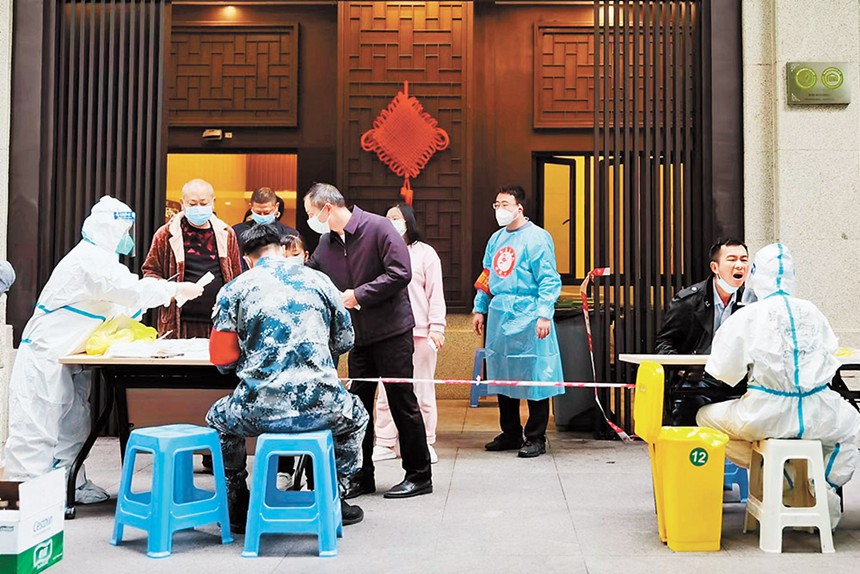 沙坪壩區退役軍人紅巖志愿服務隊為小區居民采集核酸樣本。（沙坪壩區退役軍人事務局供圖）