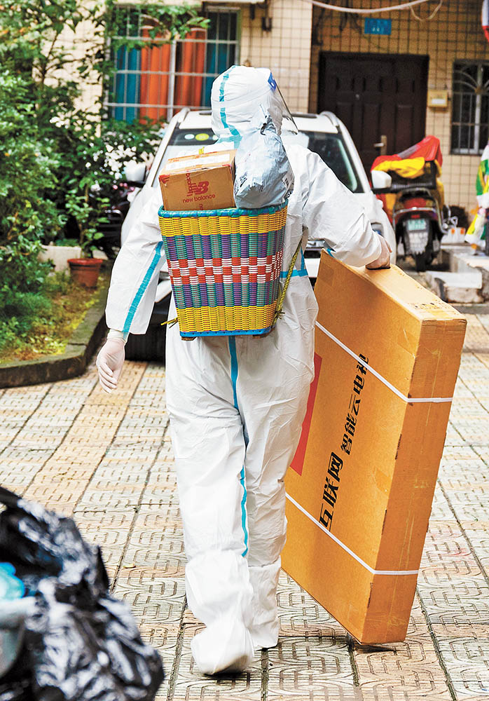 11月14日，萬州區雙堰塘社區，山東籍“95后”志愿者王德全為居民送物資。特約攝影 冉孟軍視覺重慶