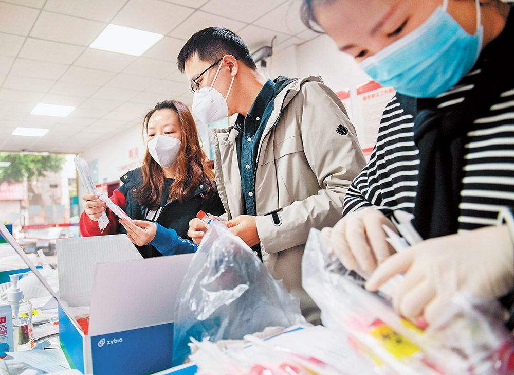 11月14日，渝北區龍山街道龍山路社區，“追陽專班”黨員、“95后”志愿者張思源(中)和同事正在準備上門復核核酸采樣的各種物資。記者 崔力 攝 視覺重慶