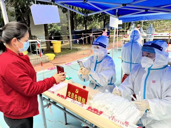 重慶機電集團所屬西計公司黨員賈碧波（右）參與核酸檢測信息采集工作。重慶機電集團供圖