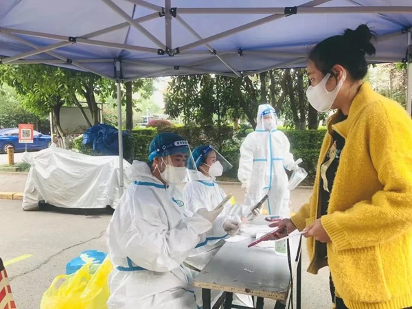 重慶市地產集團黨員冉淵（左一）協助社區進行核酸檢測信息錄入工作。重慶市地產集團供圖