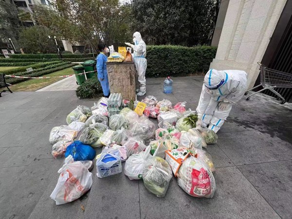 重慶銀行兩江分行黨員楊晶（右）為居民提供無接觸上門配送蔬菜、藥品等服務。重慶銀行供圖