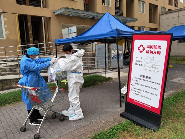 重慶交運集團黨員羅開祿協助當地社區到高風險區樓棟為住戶送生活物資。重慶交運集團供圖