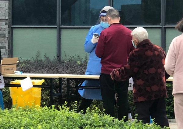 四聯集團黨員任國偉協助做好核酸檢測登記工作。四聯集團供圖