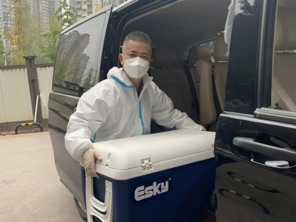 盧行正在往車上搬運物資。