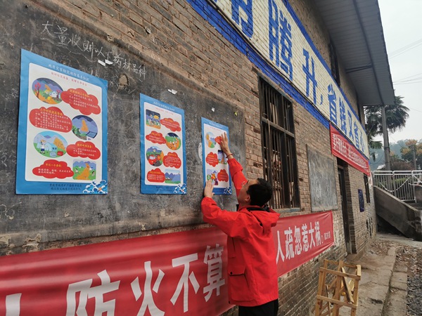 《張貼地災科普海報》。10月13日，南江地質隊駐守地質隊員李清山在涪陵區馬武鎮敬老院滑坡附近居民區張貼地災科普海報。劉黎攝