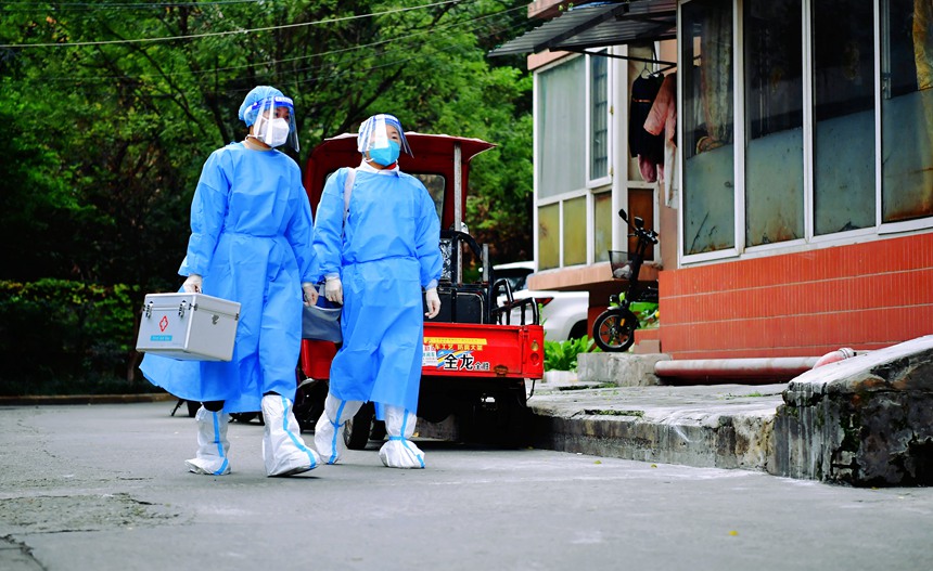 社區工作人員和醫護人員在轄區宣傳疫苗接種。周舸攝