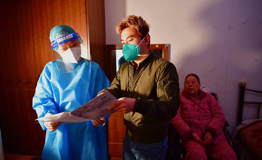 社區工作人員和醫護人員在轄區宣傳疫苗接種。周舸攝