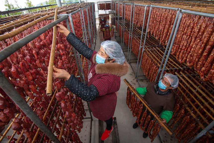 村民在寒冷中晾曬臘腸。?冉孟軍攝