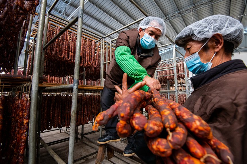 村民在寒冷中晾曬臘腸。?冉孟軍攝