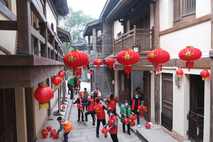 志愿者們正在為黃葛古道敦厚坡段的傳統民居貼春聯，掛燈籠。郭旭攝