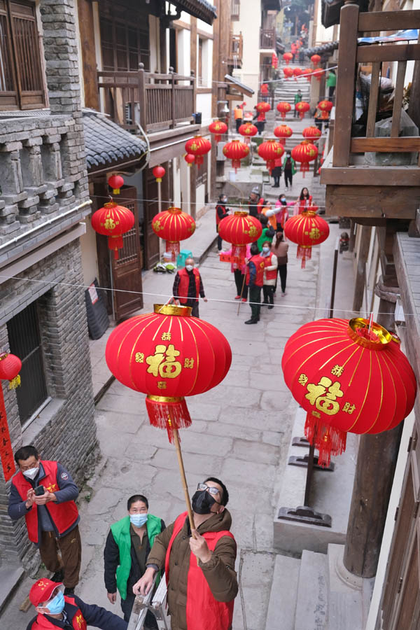 志愿者們正在為黃葛古道敦厚坡段的傳統民居貼春聯，掛燈籠。郭旭攝