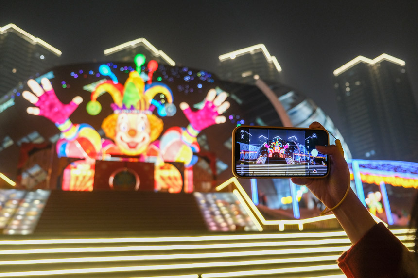 觀眾在燈飾《快樂騎士》留影。郭旭攝