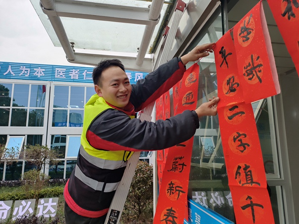 建設者將寫好的春聯掛上。