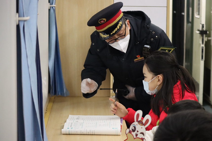 在5609次列車上，列車長王友為乘車的小學生講解車內服務設備。羅希雅攝
