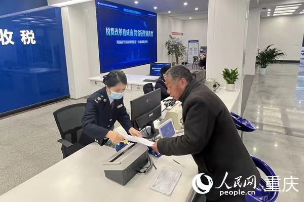 川渝高竹新區稅費征管中心工作人員為納稅人開票。人民網 胡虹攝