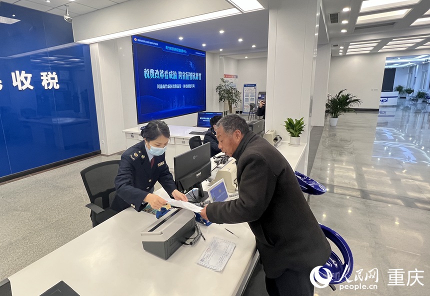 川渝高竹新區稅費征管中心工作人員為納稅人開票。人民網 胡虹攝
