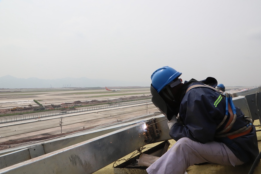 4月29日，工作人員在重慶江北國際機場T3B航站樓施工現場進行屋面施工。中建八局供圖