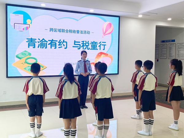 圖為在榮昌稅務法治教育基地，通過視頻連線，榮昌區稅務人員正帶領榮昌、青島兩地的學生們同步參觀基地。文明燕攝