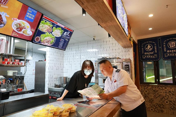 近日，沙坪壩區稅務人員走進酸辣粉店，宣傳個體工商戶相關稅費優惠政策，點對點答疑解難。陳賽亞攝