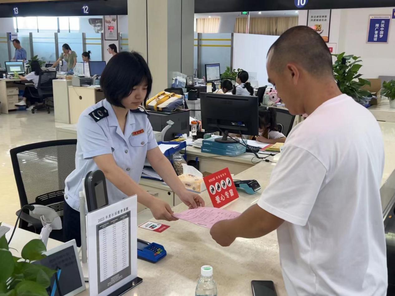 在大足區辦稅服務廳，愛心專窗稅務人員正在為殘疾人士辦理涉稅業務。蔣寧澤攝