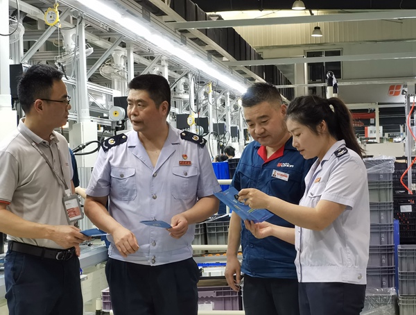 在重慶隆鑫發動機有限公司，高新區稅務局人員宣傳輔導研發費用加計扣除等稅收優惠政策。王玉婷攝