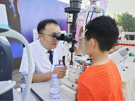 周自強為現場市民義診。重慶愛爾眼科醫院總院供圖